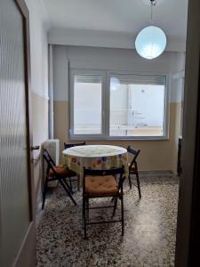a dining room with a table and chairs and two windows at Emme Central - spacious apartment in Kavala +10 photos