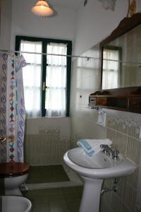 a bathroom with a sink and a toilet and a mirror at Villa Cantagallo in Cortona