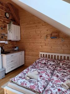1 dormitorio con 1 cama en una pared de madera en Chalupa pod Volarským rondelem en Volary