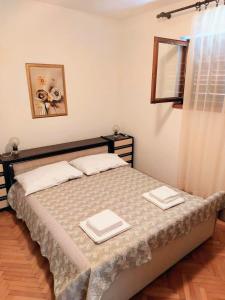 a bedroom with a bed with two plates on it at Apartment Nadalina in Seget Vranjica