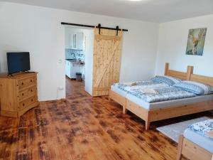 a bedroom with two beds and a sliding door at Chalupa pod Volarským rondelem in Volary