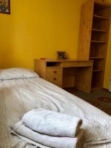 a bedroom with a desk and a bed with towels at Słoneczny Apartament 3 - oddzielne pokoje Centrum Jarot in Olsztyn