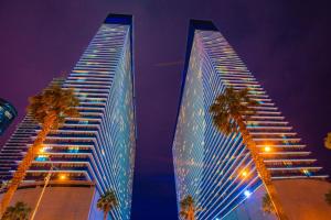 two tall buildings with palm trees in front of them at Orbi City Hotel Official in Batumi