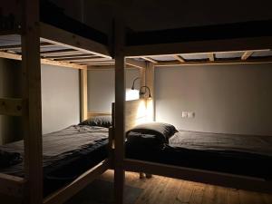 two bunk beds in a dark room with a lamp at Boutique Hostel Cesis-X in Cēsis