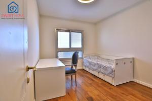 Habitación pequeña con escritorio y cama en Sea view family relax apartment, en Netanya