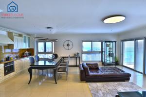 cocina y sala de estar con sofá y mesa en Sea view family relax apartment, en Netanya