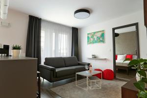 uma sala de estar com um sofá e um espelho em Modern apartment near the city centre URBAN em Bratislava