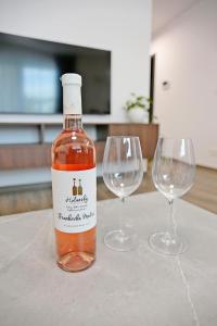 uma garrafa de vinho e dois copos de vinho numa mesa em Modern apartment near the city centre URBAN em Bratislava