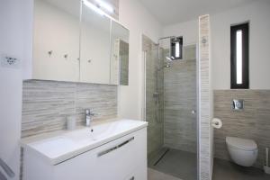 W łazience znajduje się umywalka, prysznic i toaleta. w obiekcie Villa Broda w mieście Brodarica