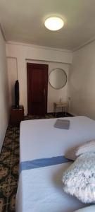 a bedroom with a large white bed and a television at Habitación doble cerca al centro. in Valencia