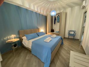 a bedroom with a blue bed and a table at Civuleva! Casa vacanza Capo d Orlando in Capo dʼOrlando