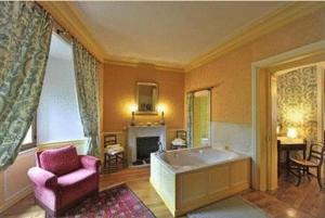- un salon avec une baignoire et une chaise dans l'établissement Château De Vollore, à Vollore-Ville