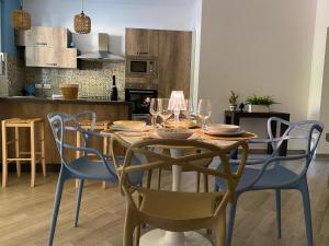 a dining room table with chairs and wine glasses at Civuleva! Casa vacanza Capo d Orlando in Capo dʼOrlando
