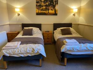 a bedroom with two beds and two night stands at Queens Ground in Sheffield