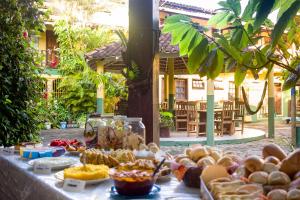 a table with food on it in front of a building at Hospedagem La Bilbaina in Porto Seguro