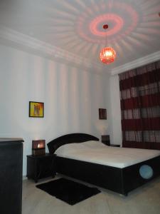 1 dormitorio con cama y lámpara de araña en Appartement LaVie, en Túnez
