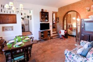 a living room with a table and a tv at Appartamento Le Macine in Isola d'Arbia