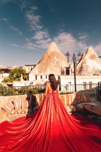 a woman in a red dress sitting on a couch at Goreme Valley Cave House in Göreme