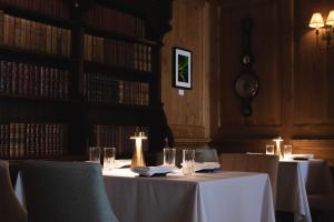 a dining room with two tables with glasses and books at Mingary Castle - Restaurant with Rooms in Kilchoan