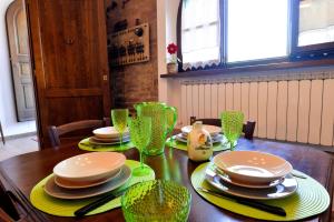 a dining room table with plates and glasses on it at Appartamento Le Macine in Isola d'Arbia