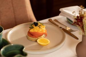 a plate of food with a piece of bread and a lemon at Mingary Castle - Restaurant with Rooms in Kilchoan