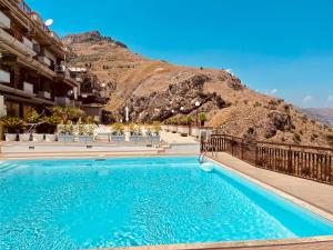 a swimming pool with a mountain in the background at Little Paradise in Taormina