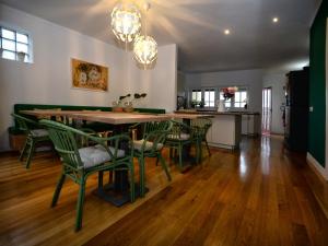 a dining room with a table and green chairs at GuimaraesLiving - Hostel & Adventure in Guimarães