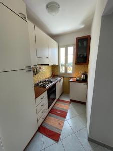 uma cozinha com armários brancos e um frigorífico em Casa Cioppy em Cala Gonone
