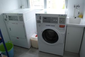 uma lavandaria com uma máquina de lavar roupa e um lavatório em Albergue Trabazo em Silleda