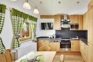 una pequeña cocina con armarios de madera y una mesa. en Apartment Auhäusl, en Mittersill