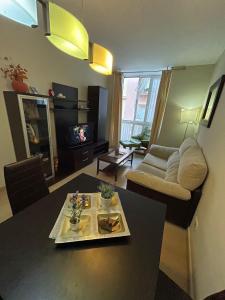 salon ze stołem i kanapą w obiekcie Los Boliches, modernos aptos 1 y 2 Dormitorios fantástica ubicación w mieście Fuengirola