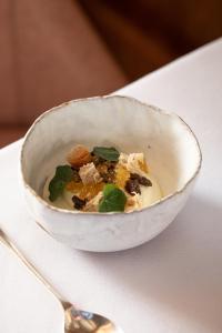 a bowl of food on a table with a spoon at Mingary Castle - Restaurant with Rooms in Kilchoan