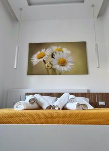 a picture of daisies on a wall with towels at in Via Margherita in Santa Maria di Castellabate