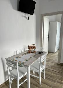 a white dining room table with two white chairs at in Via Margherita in Santa Maria di Castellabate