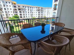 un tavolo blu e sedie su un balcone con un edificio di Lovely 2-Bed Apartment in Marina de la Duquesa a Castillo de Sabinillas