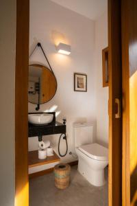 a bathroom with a sink and a toilet and a mirror at Residencial Recanto Tropical, alto padrão e conforto pertinho da praia em Arraial dAjuda in Porto Seguro
