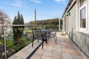 patio con mesa y sillas en el balcón en Elmo Lodge en Salcombe