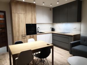 cocina con mesa y sillas en una habitación en Tesorio Apartment - AC, Free Parking, WiFi, Business & Family, en Wroclaw