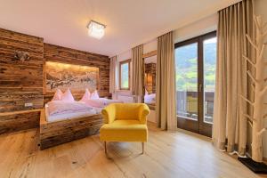 ein Schlafzimmer mit 2 Betten und einem gelben Stuhl in der Unterkunft Atelier Garni Astei in Großarl
