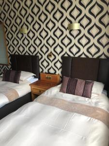 インバネスにあるBraehead Guest Houseのベッド2台と壁が備わるホテルルームです。