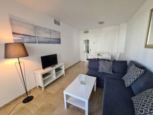 un soggiorno con divano blu e TV di Lovely 2-Bed Apartment in Marina de la Duquesa a Castillo de Sabinillas