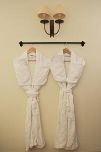 two white robes are hanging on a wall at Mingary Castle - Restaurant with Rooms in Kilchoan