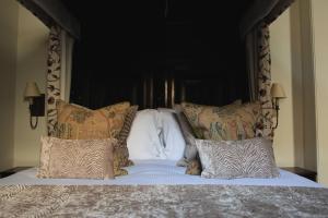 a large bed with a black headboard and pillows at Mingary Castle - Restaurant with Rooms in Kilchoan