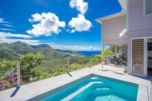 Cette villa dispose d'une piscine et offre une vue sur l'océan. dans l'établissement DOMAINE DE MAPOU, à Les Anses-d'Arlet