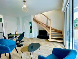 a living room with a staircase and blue chairs at Villa Elisa M in Aubenas