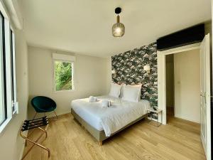 a bedroom with a bed and a chair in it at Villa Elisa M in Aubenas