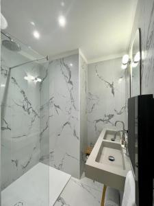 a bathroom with a sink and a glass shower at Villa Elisa M in Aubenas