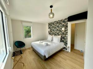 a bedroom with a white bed and white walls at Villa Elisa M in Aubenas