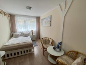 a bedroom with a bed and a table and a couch at Pod Aniołem in Mielno