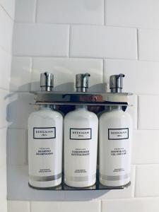 three bottles of soap on a shelf in a bathroom at HighRoad Washington DC in Washington, D.C.